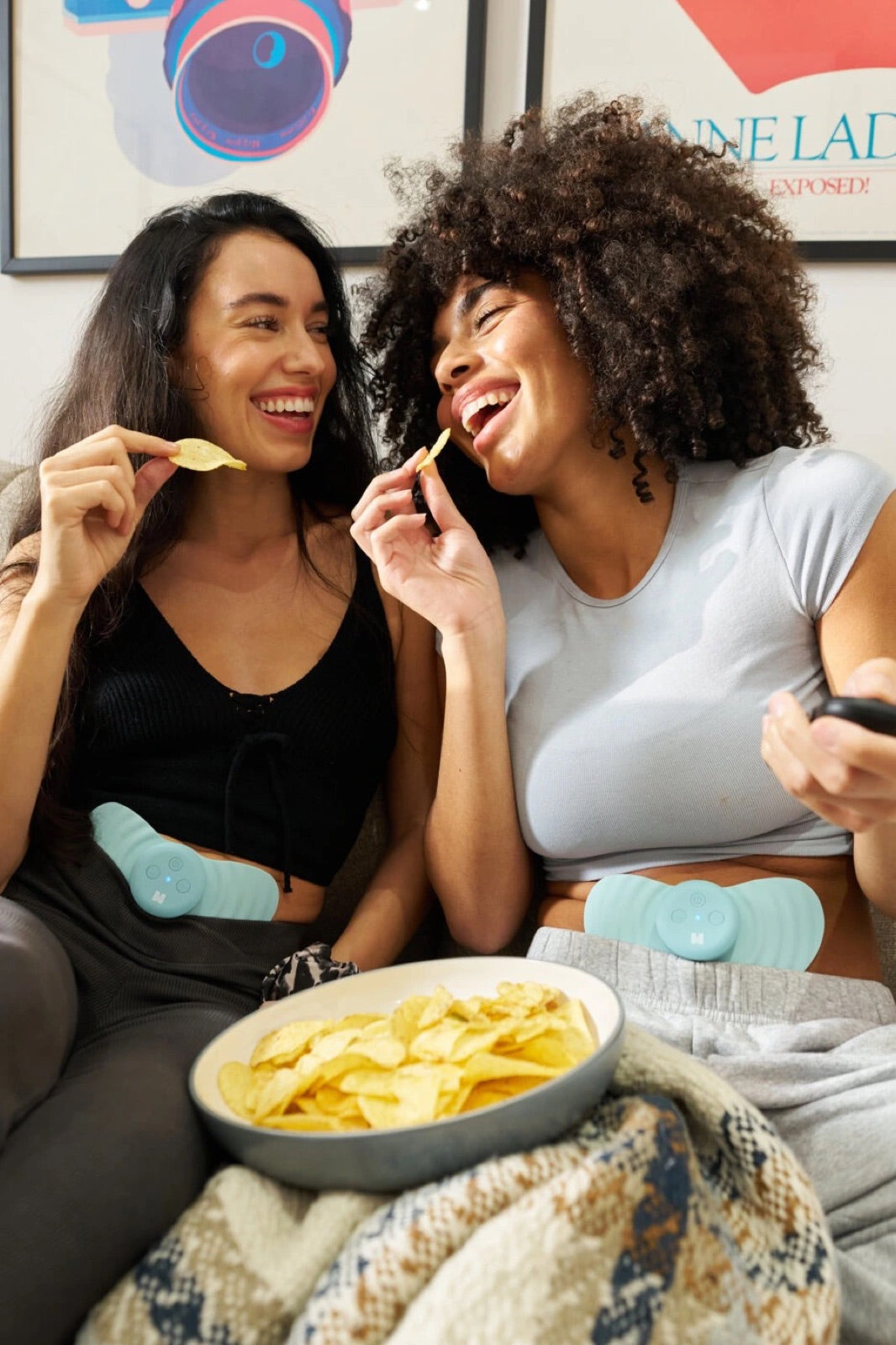 Two friends laughing on a sofa, both wearing Myoovi 2.0